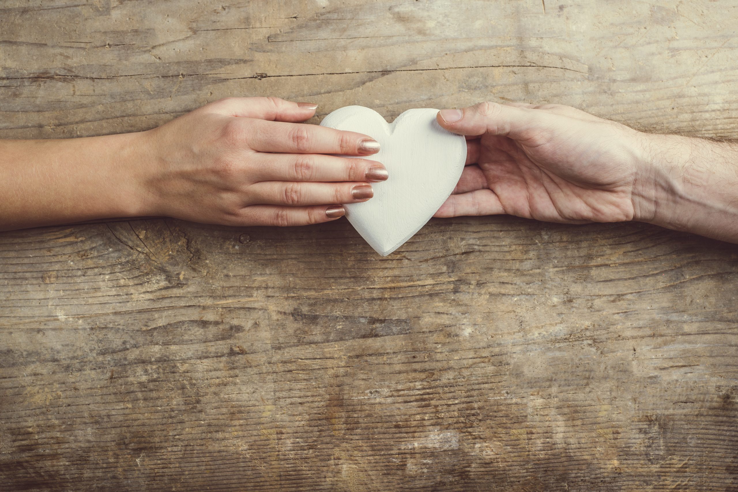 Hands of man and woman connected through a heart.